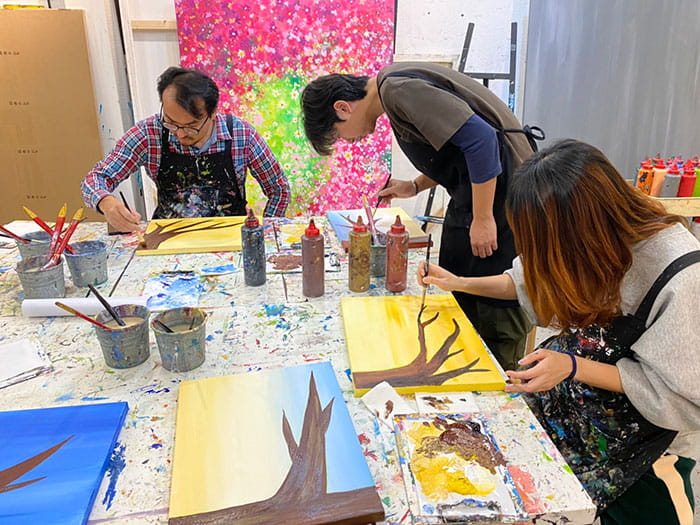Mitarbeiter aus Bossard Taiwan malen  Bilder auf dem Tisch