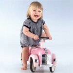 Kind mit sitzt auf einem Spielzeugauto 